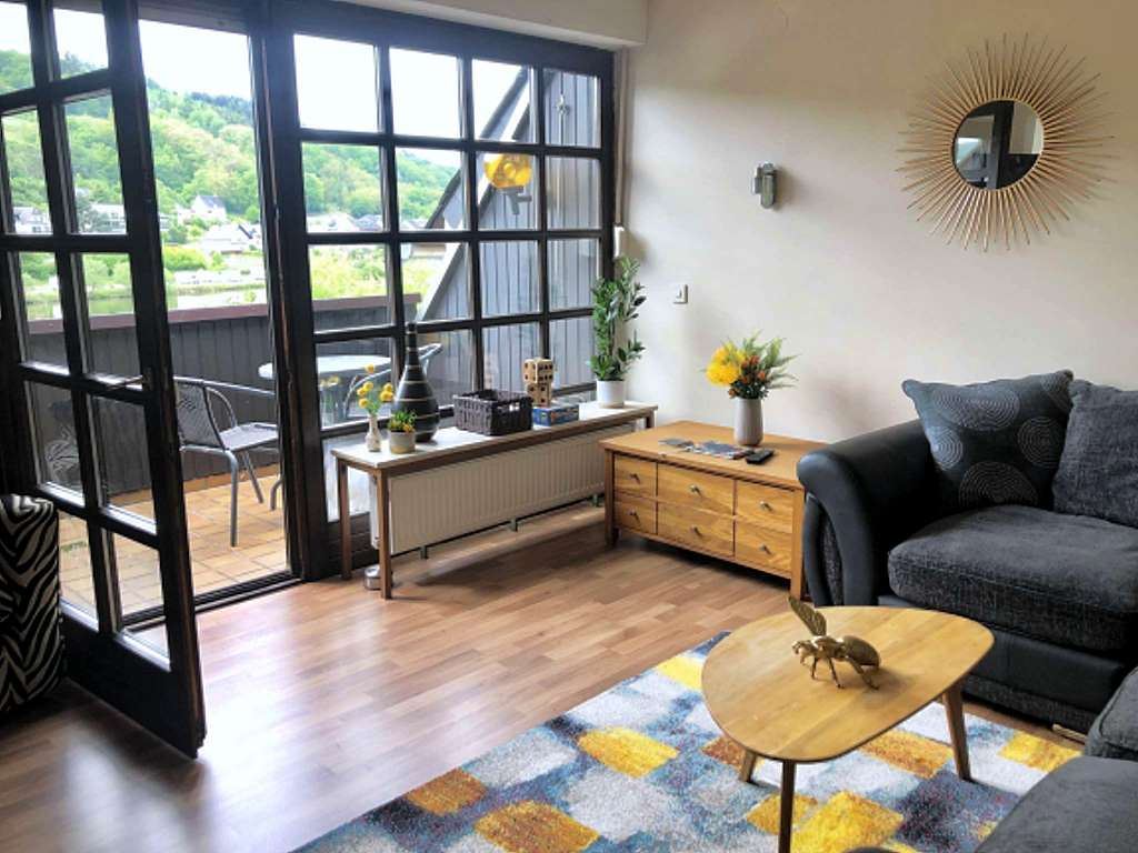 Wohnzimmer und Balkom mit Moselblick - Moselurlaub in Ferienwohnung Moselwein in Ferienhaus Am Moselradweg, Schlossstraße 31, 56856 Zell (Mosel)